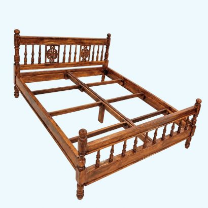 Premium carved wooden bed online made from solid Sheesham wood with an elegant carved headboard and classic spindle design.