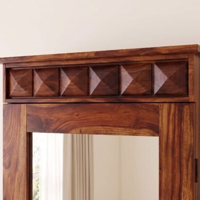 Traditional solid sheesham wood dressing table with full length mirror cabinet, carved diamond crown, and 2 bottom drawers in natural honey finish, placed in a well-lit bedroom